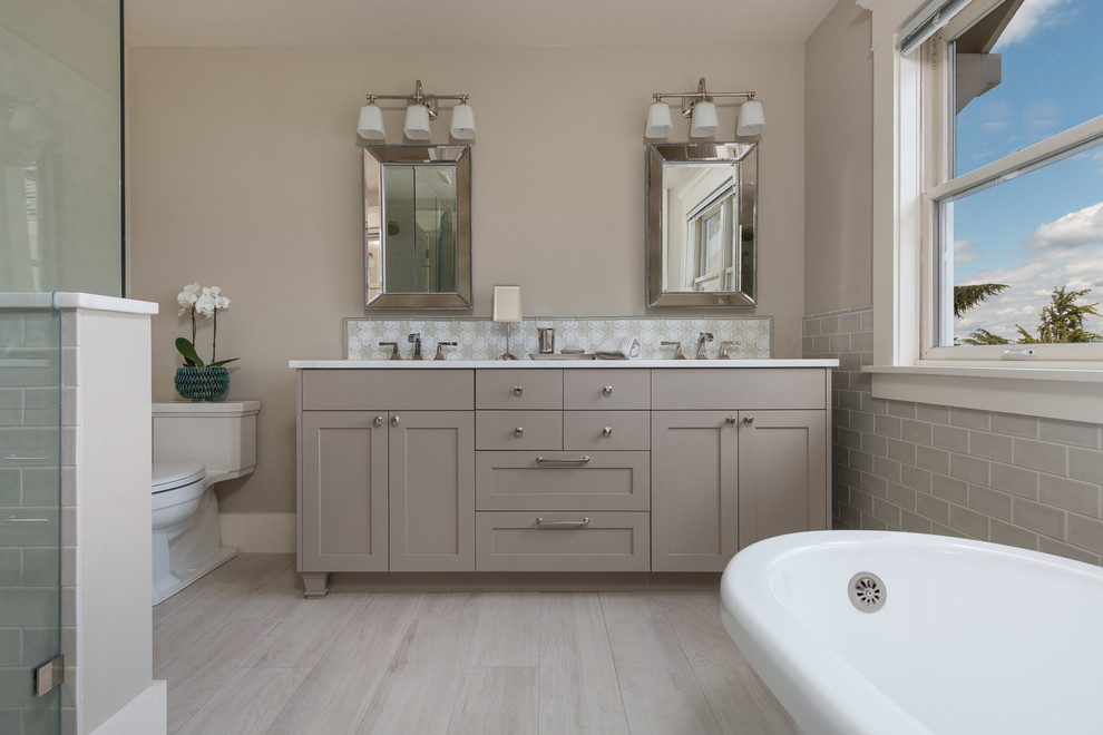 Inspiration for a medium sized rural ensuite bathroom in Seattle with shaker cabinets, grey cabinets, a claw-foot bath, a corner shower, a two-piece toilet, grey tiles, ceramic tiles, grey walls, porcelain flooring, a submerged sink and quartz worktops.