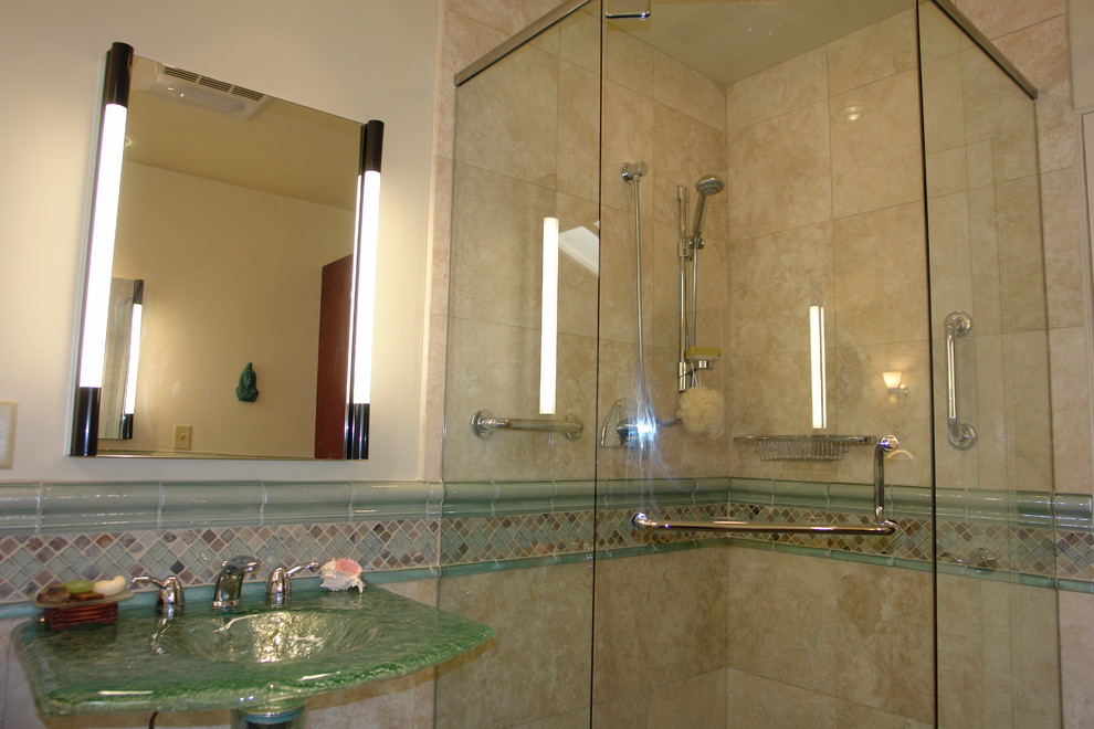 This is an example of a medium sized beach style ensuite bathroom in San Diego with open cabinets, blue cabinets, a corner bath, a corner shower, a one-piece toilet, beige tiles, blue tiles, brown tiles, grey tiles, multi-coloured tiles, white tiles, mosaic tiles, beige walls, porcelain flooring, a pedestal sink and glass worktops.