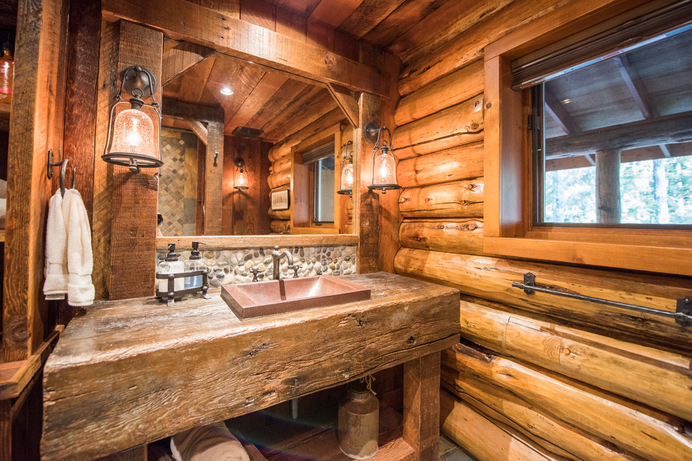 На фото: ванная комната в деревянном доме в стиле рустика с душем в нише, настольной раковиной и столешницей из дерева с