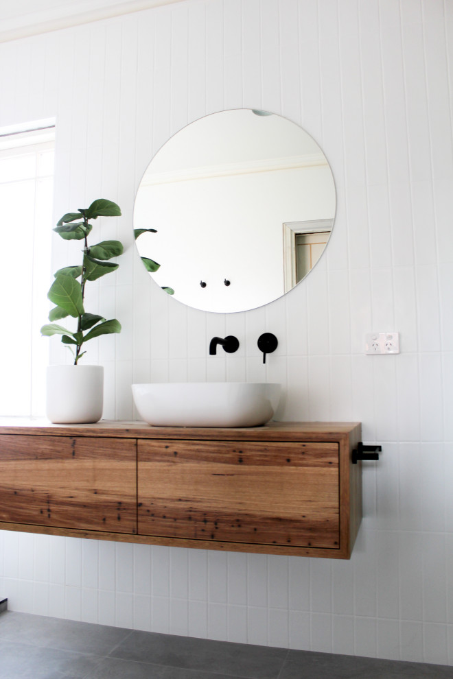 Idée de décoration pour une grande salle de bain principale minimaliste en bois brun avec un placard en trompe-l'oeil, une baignoire indépendante, une douche d'angle, WC à poser, un carrelage blanc, un carrelage métro, un mur blanc, un sol en carrelage de porcelaine, une vasque, un plan de toilette en bois, un sol gris, une cabine de douche à porte battante, un plan de toilette multicolore, meuble simple vasque et meuble-lavabo suspendu.