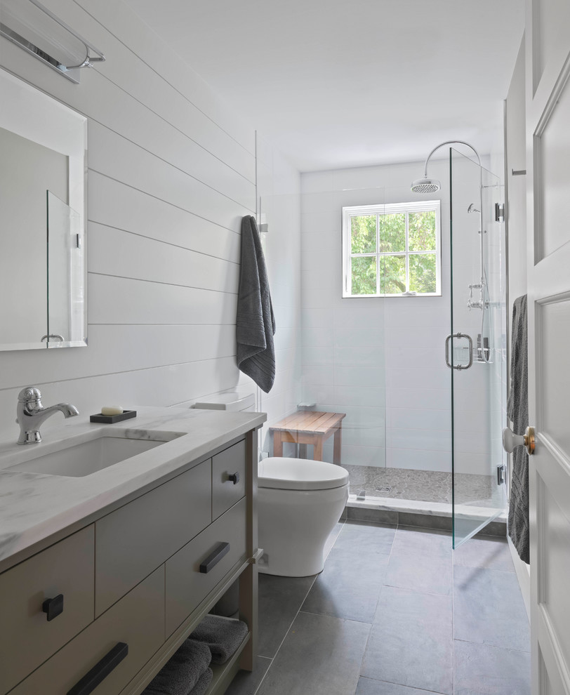 Пример оригинального дизайна: ванная комната среднего размера с плоскими фасадами, серыми фасадами, душем в нише, серыми стенами, полом из сланца, душевой кабиной, врезной раковиной, мраморной столешницей, коричневым полом и душем с распашными дверями