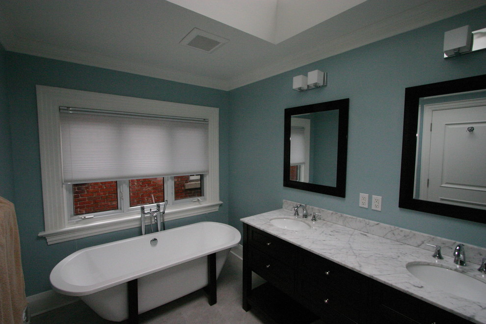 Example of a minimalist ceramic tile bathroom design in Toronto with furniture-like cabinets, dark wood cabinets, marble countertops, a one-piece toilet, blue walls and an undermount sink