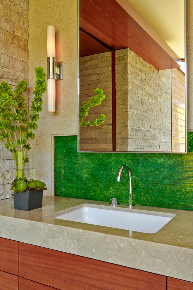 サンフランシスコにあるラグジュアリーな広いコンテンポラリースタイルのおしゃれな浴室 (アンダーカウンター洗面器、フラットパネル扉のキャビネット、中間色木目調キャビネット、ライムストーンの洗面台、一体型トイレ	、緑のタイル、石スラブタイル、ベージュの壁、ライムストーンの床) の写真