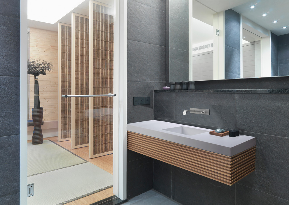 Idéer för mellanstora orientaliska en-suite badrum, med släta luckor, skåp i ljust trä, grå kakel, stenkakel, grå väggar, ett väggmonterat handfat, bänkskiva i kvarts och grått golv