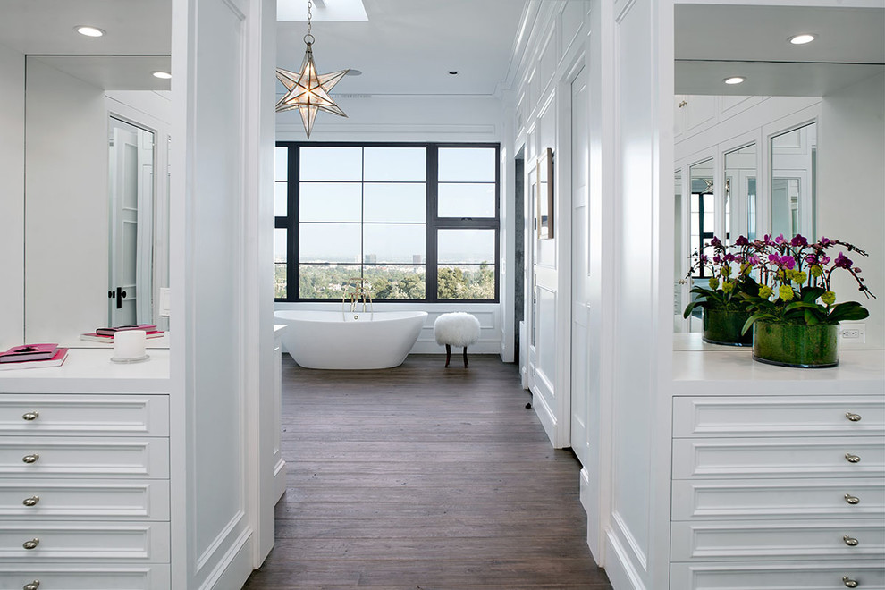 Photo of a large traditional ensuite bathroom in Other with beaded cabinets, white cabinets, a freestanding bath, white walls, dark hardwood flooring and engineered stone worktops.