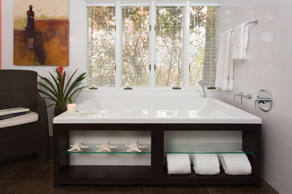 Modelo de cuarto de baño principal minimalista de tamaño medio con armarios abiertos, puertas de armario de madera en tonos medios, bañera empotrada, suelo de madera oscura y encimera de acrílico