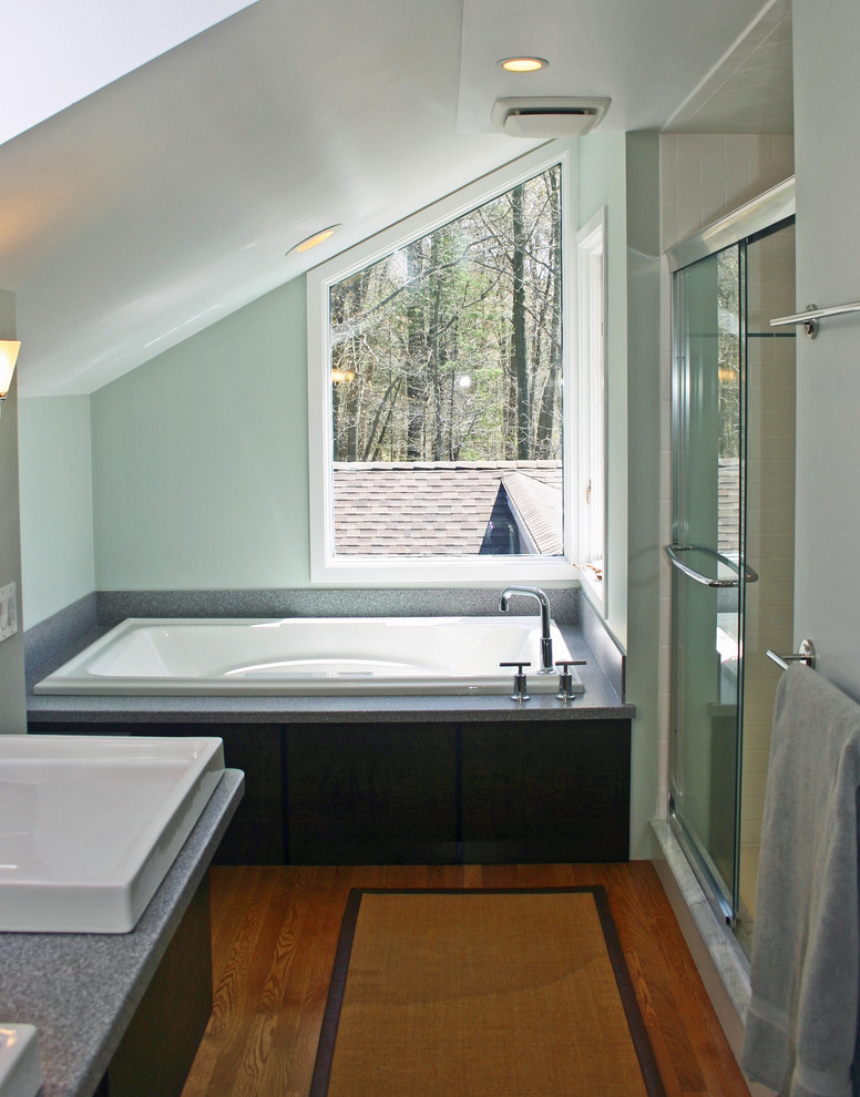 Exemple d'une douche en alcôve principale tendance en bois foncé de taille moyenne avec un placard à porte plane, un plan de toilette en surface solide, une baignoire posée, un sol en bois brun, un mur vert, une vasque et une cabine de douche à porte coulissante.