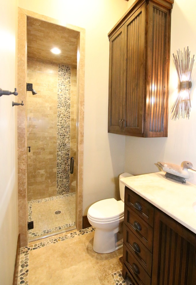 Пример оригинального дизайна: ванная комната среднего размера в стиле рустика с фасадами с филенкой типа жалюзи, темными деревянными фасадами, душем в нише, унитазом-моноблоком, галечной плиткой, белыми стенами, полом из травертина и врезной раковиной