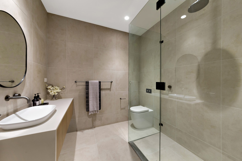 Modern inredning av ett mellanstort vit vitt badrum, med släta luckor, skåp i mellenmörkt trä, ett fristående badkar, en öppen dusch, grå kakel, porslinskakel, grå väggar, klinkergolv i porslin, ett fristående handfat, bänkskiva i kvarts, grått golv och med dusch som är öppen