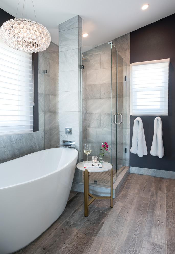 Inredning av ett klassiskt mellanstort grå grått en-suite badrum, med dusch med gångjärnsdörr, ett fristående badkar, en öppen dusch, grå kakel, marmorkakel, svarta väggar, klinkergolv i porslin, marmorbänkskiva och grått golv