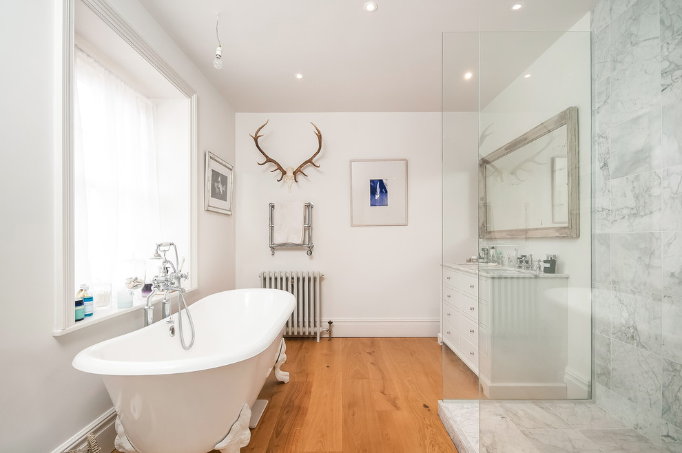 Design ideas for a medium sized traditional ensuite bathroom in Hampshire with white cabinets, a claw-foot bath, porcelain tiles, white walls, medium hardwood flooring, granite worktops, brown floors, an open shower, a corner shower, grey tiles, a submerged sink and flat-panel cabinets.