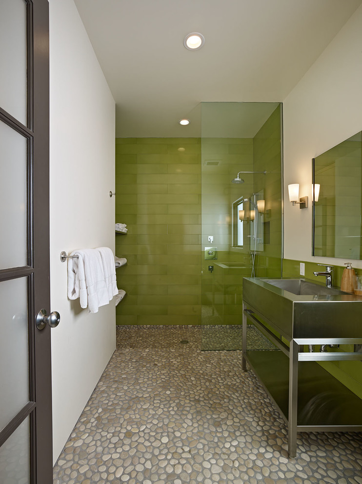 Cette photo montre une salle de bain tendance avec un plan vasque, un placard sans porte, une douche ouverte, un carrelage vert, un carrelage en pâte de verre, un sol en galet et aucune cabine.