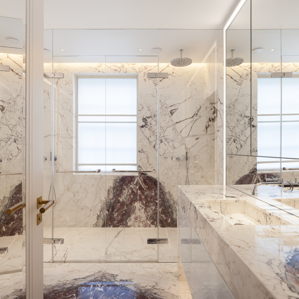 Bild på ett mellanstort funkis en-suite badrum, med släta luckor, vita skåp, en öppen dusch, en vägghängd toalettstol, vit kakel, marmorkakel, vita väggar, marmorgolv, ett integrerad handfat, marmorbänkskiva, vitt golv och dusch med gångjärnsdörr
