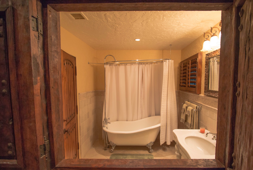 Inspiration för ett mellanstort amerikanskt badrum med dusch, med ett badkar med tassar, en dusch/badkar-kombination, en toalettstol med hel cisternkåpa, beige kakel, keramikplattor, beige väggar, klinkergolv i keramik och ett konsol handfat