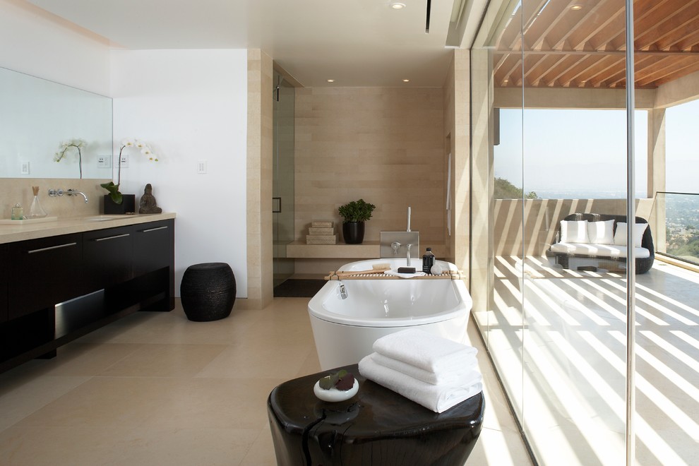 Exemple d'une grande douche en alcôve principale tendance en bois foncé avec un placard à porte plane, une baignoire indépendante, un carrelage beige, un lavabo encastré, un sol beige et une cabine de douche à porte battante.