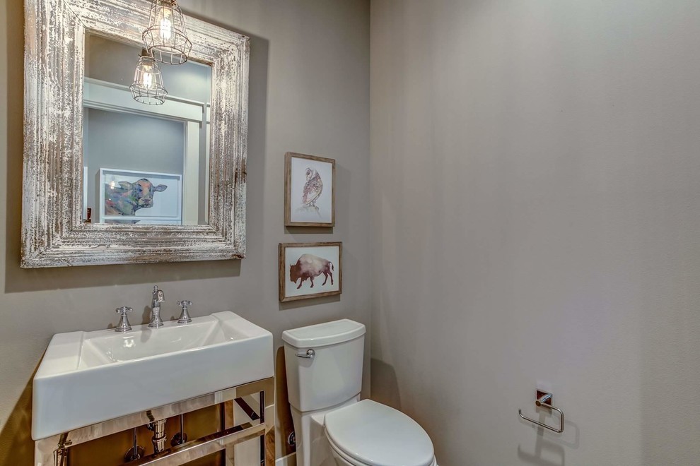 Modelo de cuarto de baño de estilo de casa de campo pequeño con puertas de armario blancas, sanitario de una pieza, paredes grises, suelo laminado, aseo y ducha, lavabo sobreencimera y suelo gris