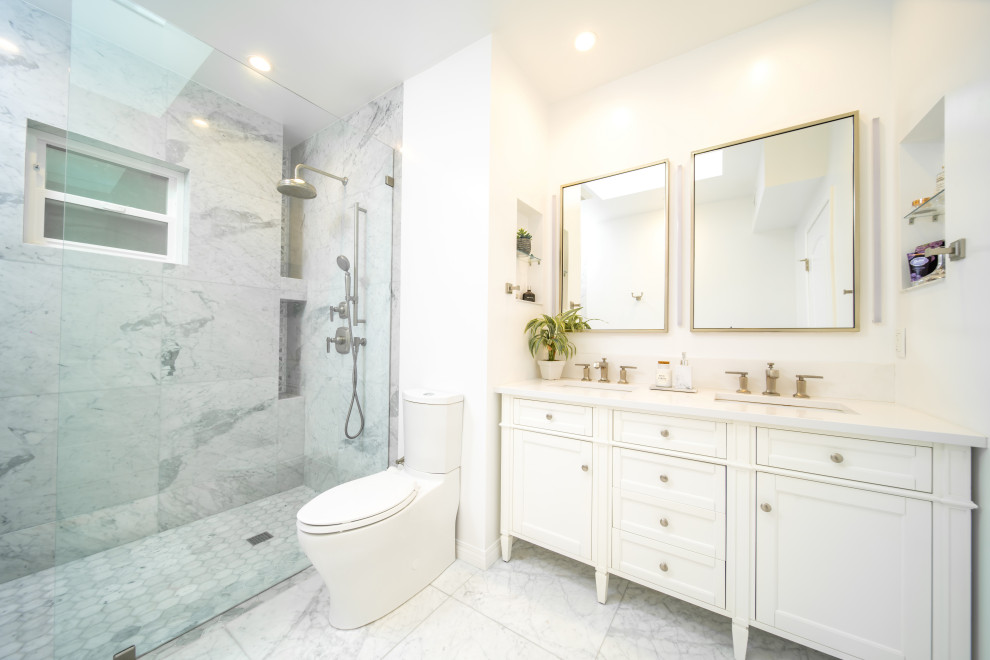 Пример оригинального дизайна: большая главная, серо-белая ванная комната в стиле неоклассика (современная классика) с фасадами в стиле шейкер, белыми фасадами, открытым душем, раздельным унитазом, разноцветной плиткой, мраморной плиткой, белыми стенами, мраморным полом, столешницей из искусственного кварца, разноцветным полом, душем с распашными дверями, белой столешницей, нишей, окном, тумбой под две раковины, напольной тумбой и врезной раковиной