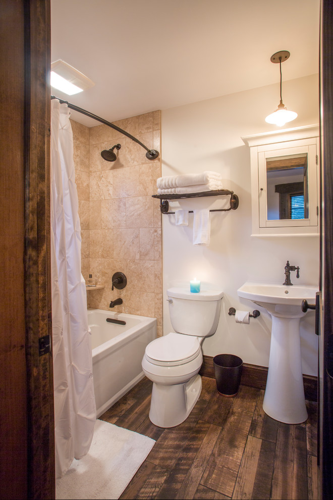 Kleines Badezimmer mit Duschbadewanne, braunem Holzboden, Sockelwaschbecken und Duschvorhang-Duschabtrennung in Sonstige