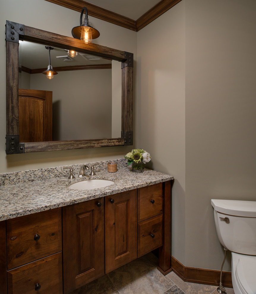 Foto di una stanza da bagno tradizionale con ante con bugna sagomata, pareti beige, pavimento con piastrelle in ceramica, lavabo sottopiano, top in granito e pavimento beige