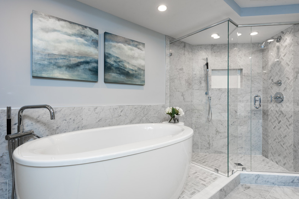 Immagine di una stanza da bagno chic con vasca freestanding, doccia ad angolo, piastrelle grigie, pavimento in gres porcellanato, pavimento grigio, porta doccia a battente e pareti blu