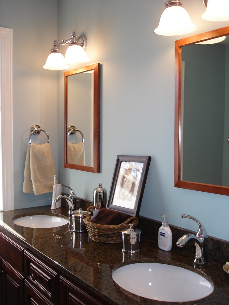 Esempio di una stanza da bagno padronale con ante in legno bruno, pareti blu e lavabo sottopiano