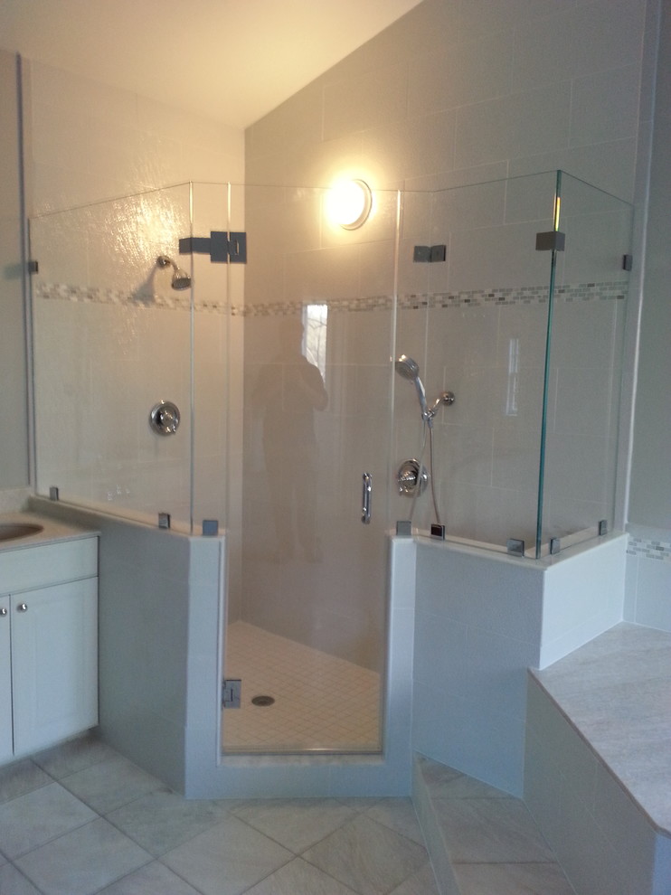 Photo of a large classic ensuite bathroom in Baltimore with white cabinets, a corner shower, beige tiles, ceramic tiles, beige walls, porcelain flooring, an integrated sink, raised-panel cabinets, solid surface worktops, beige floors and a hinged door.