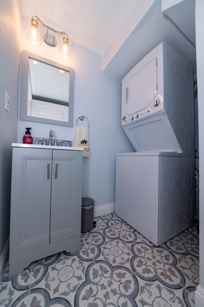 Пример оригинального дизайна: маленькая ванная комната со стиральной машиной с фасадами в стиле шейкер, серыми фасадами, унитазом-моноблоком, серой плиткой, цементной плиткой, серыми стенами, полом из цементной плитки, душевой кабиной, накладной раковиной, столешницей из кварцита, разноцветным полом, белой столешницей, тумбой под одну раковину и напольной тумбой для на участке и в саду