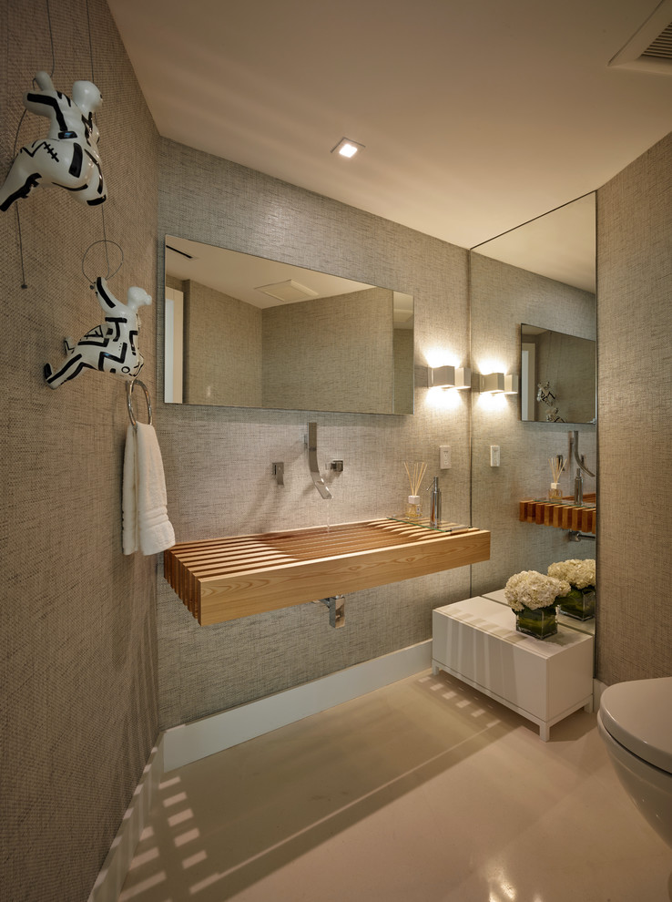 Foto di una piccola stanza da bagno con doccia design con doccia ad angolo, WC sospeso, piastrelle bianche, pareti grigie, pavimento in gres porcellanato, lavabo integrato e top in legno