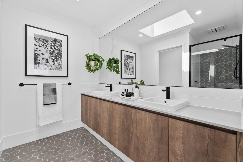 Exemple d'une grande salle de bain scandinave en bois brun avec un placard à porte plane, un mur blanc, un lavabo posé, un sol gris, une cabine de douche à porte coulissante et un plan de toilette gris.