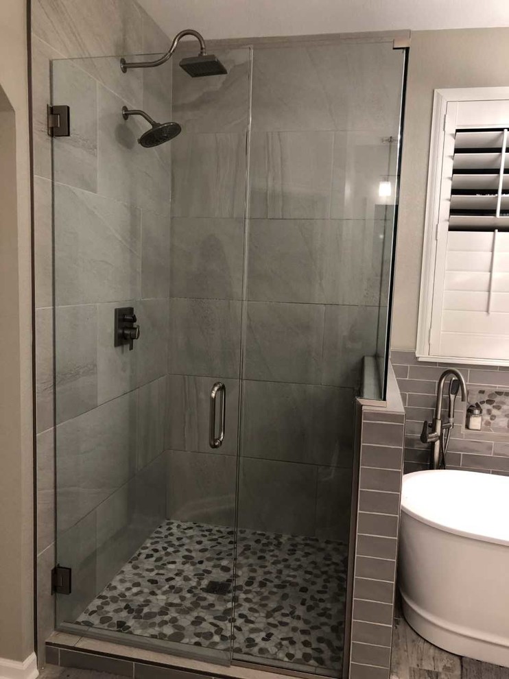 Esempio di una stanza da bagno padronale chic di medie dimensioni con vasca freestanding, doccia ad angolo, piastrelle grigie, piastrelle in gres porcellanato, pareti grigie, pavimento in gres porcellanato, pavimento grigio e doccia aperta