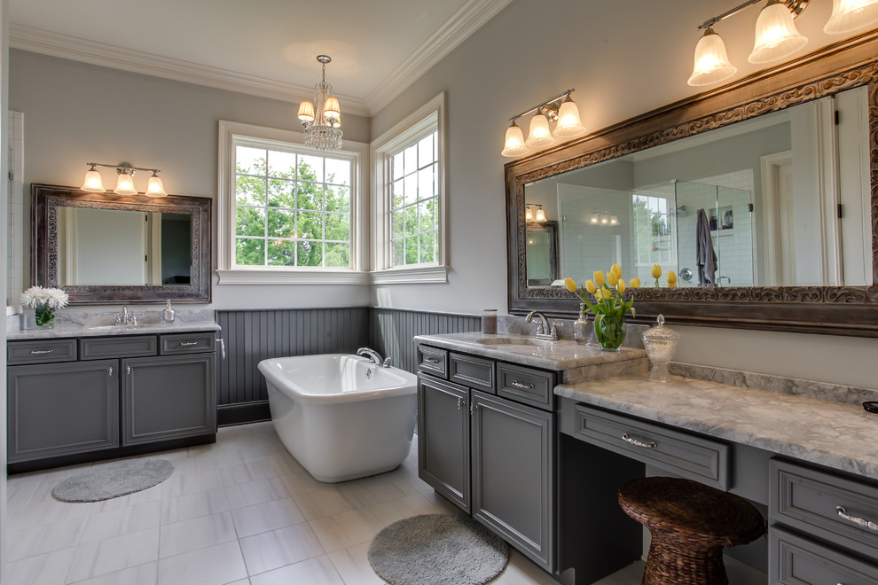 Inspiration for a timeless white tile freestanding bathtub remodel in Nashville with an undermount sink, recessed-panel cabinets and gray cabinets