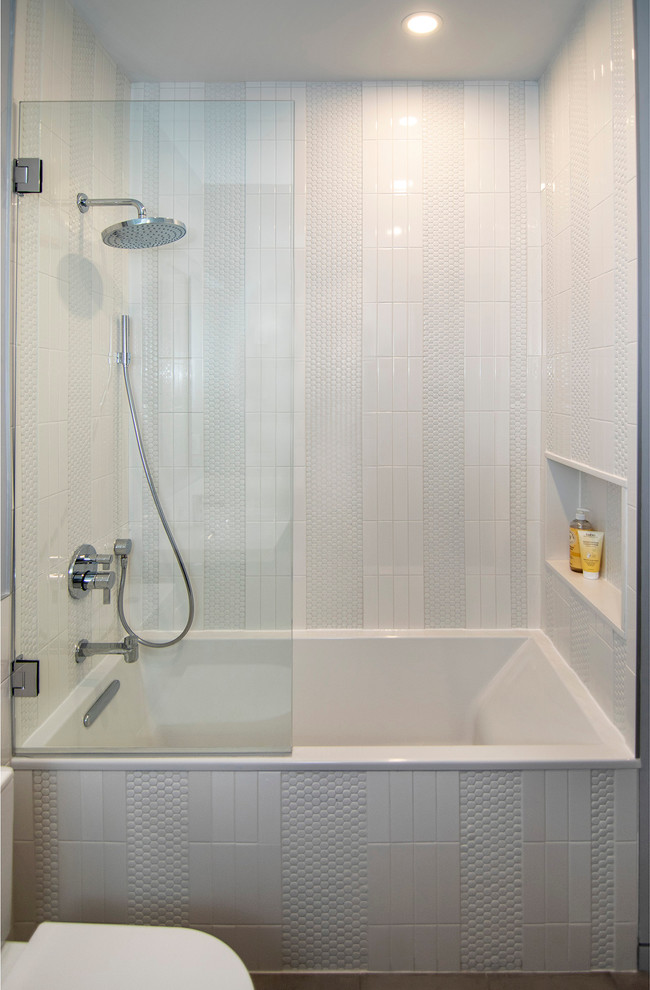 Bathroom - mid-sized modern kids' white tile and ceramic tile porcelain tile and gray floor bathroom idea in New York with flat-panel cabinets, gray cabinets, a one-piece toilet, gray walls, an integrated sink, solid surface countertops, a hinged shower door and white countertops