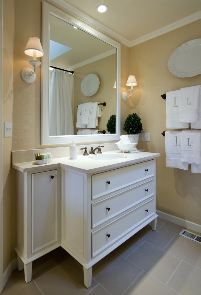 Foto di una stanza da bagno classica con lavabo sottopiano, ante bianche, piastrelle beige e ante con riquadro incassato