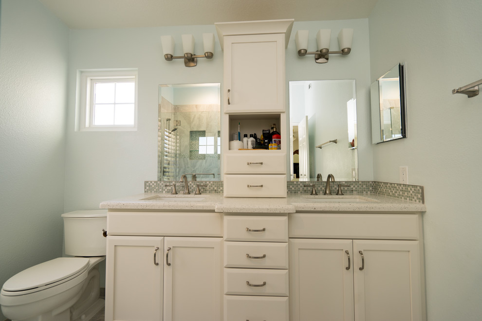 Inredning av ett klassiskt stort en-suite badrum, med luckor med infälld panel, vita skåp, en dusch i en alkov, en toalettstol med separat cisternkåpa, gul kakel, keramikplattor, blå väggar, travertin golv, ett nedsänkt handfat och bänkskiva i kvartsit