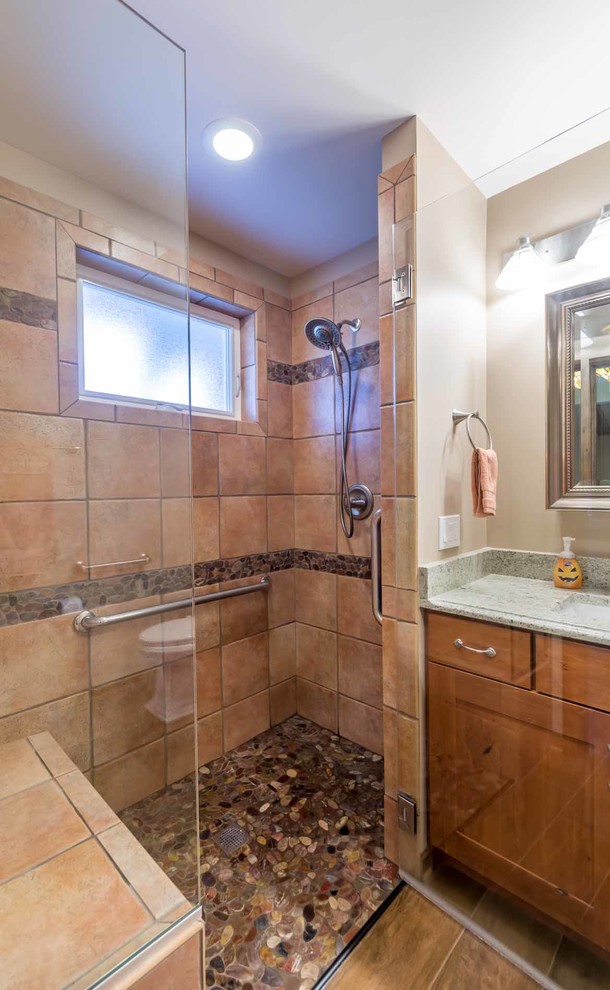 Foto på ett litet rustikt grå badrum med dusch, med skåp i shakerstil, skåp i mellenmörkt trä, en dusch i en alkov, en toalettstol med separat cisternkåpa, brun kakel, stenkakel, beige väggar, klinkergolv i keramik, ett undermonterad handfat, granitbänkskiva, dusch med gångjärnsdörr och brunt golv
