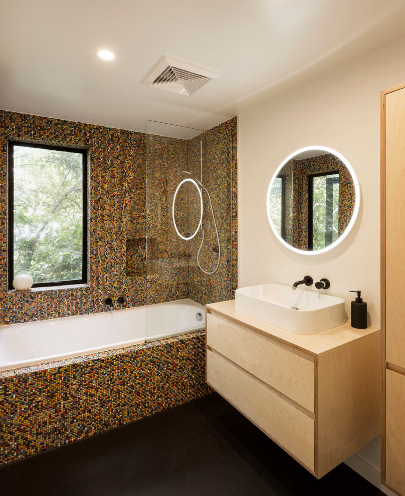Идея дизайна: главная ванная комната среднего размера в современном стиле с светлыми деревянными фасадами, накладной ванной, душем над ванной, разноцветной плиткой, керамической плиткой, белыми стенами, полом из линолеума, консольной раковиной, столешницей из дерева, черным полом, открытым душем, бежевой столешницей, тумбой под одну раковину и подвесной тумбой