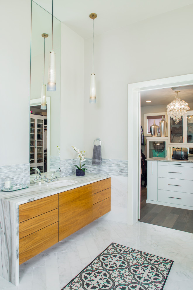 Photo of a contemporary ensuite bathroom in Austin with flat-panel cabinets, medium wood cabinets, marble worktops, white tiles, a submerged sink and grey walls.