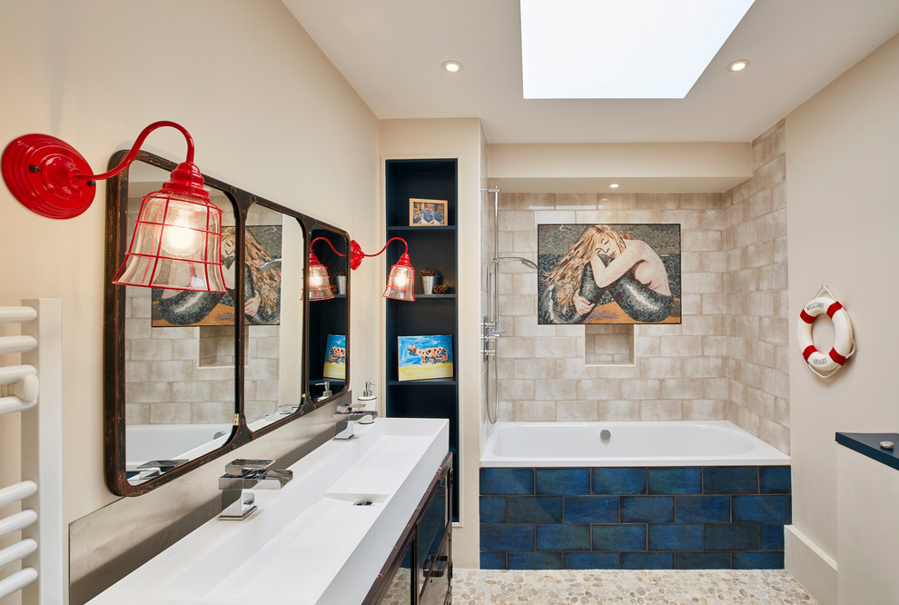 Medium sized nautical ensuite bathroom in London with an alcove bath, a shower/bath combination, beige tiles, beige walls, pebble tile flooring, a trough sink, beige floors and an open shower.