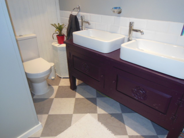 Example of a mid-sized cottage chic white tile drop-in bathtub design in Hampshire with furniture-like cabinets and wood countertops