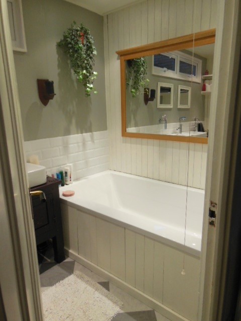 Immagine di una stanza da bagno stile shabby di medie dimensioni con consolle stile comò, top in legno, vasca da incasso e piastrelle bianche