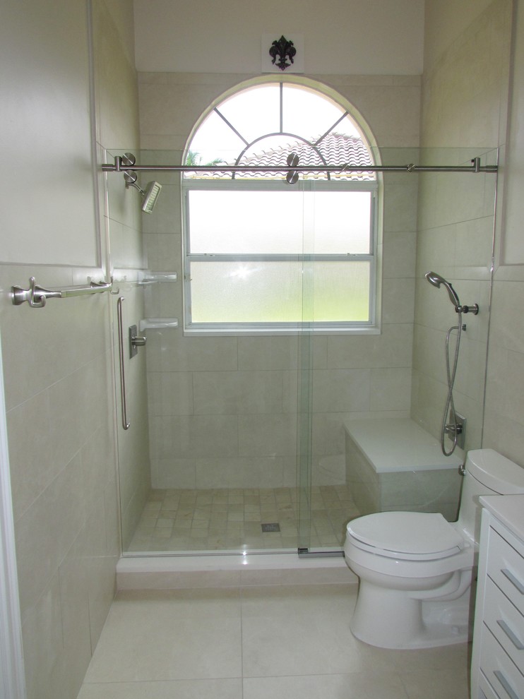 На фото: ванная комната среднего размера в стиле модернизм с фасадами с декоративным кантом, белыми фасадами, душем в нише, унитазом-моноблоком, бежевой плиткой, плиткой из известняка, бежевыми стенами, полом из керамогранита и душевой кабиной с