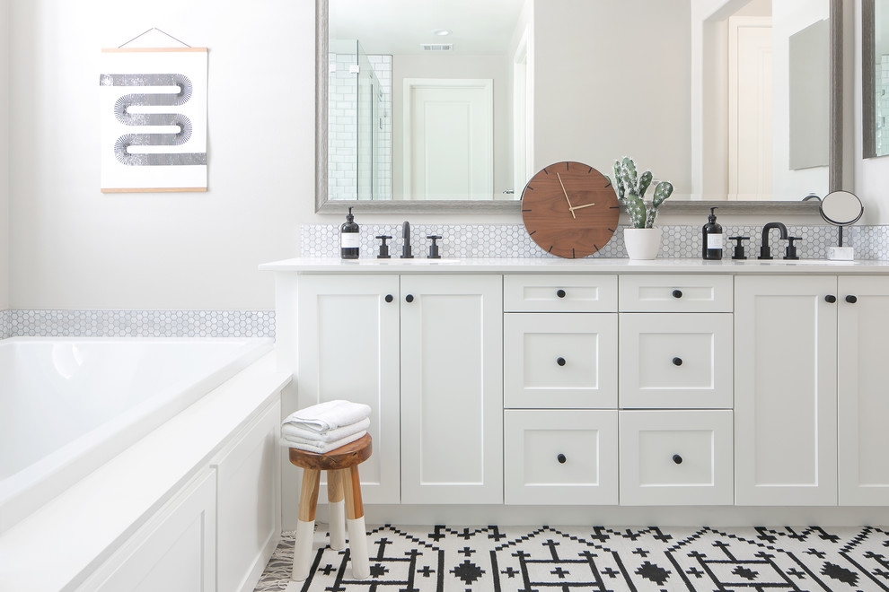Idee per una stanza da bagno tradizionale con ante in stile shaker, ante bianche, vasca da incasso, piastrelle bianche, piastrelle a mosaico, pareti grigie, lavabo sottopiano e top bianco