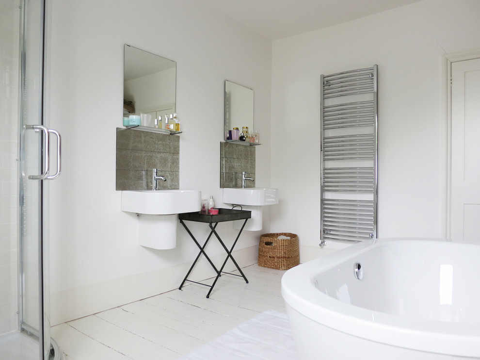 Immagine di una stanza da bagno bohémian con lavabo sospeso, vasca freestanding, pavimento in legno verniciato, pavimento bianco e lavanderia