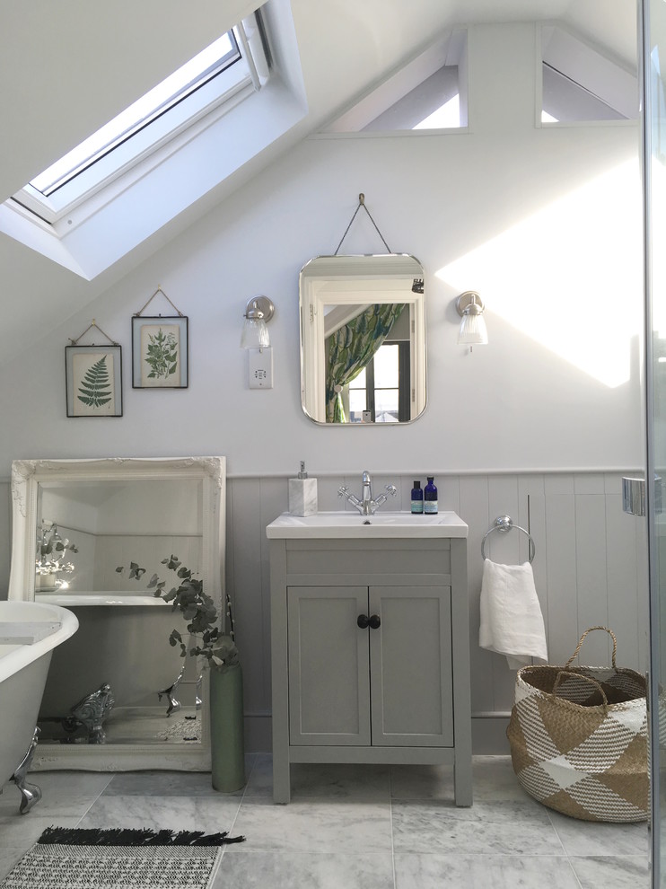 Cette image montre une petite salle de bain traditionnelle avec une baignoire sur pieds, un mur blanc, un sol en marbre, un lavabo encastré et un sol gris.