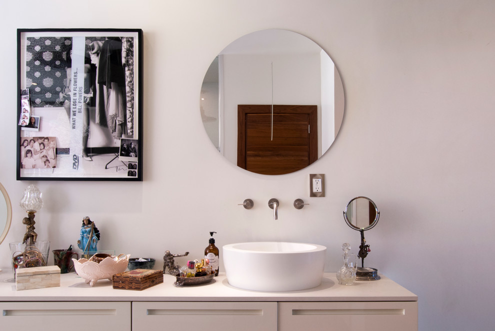 Large contemporary ensuite bathroom in New York with a vessel sink, flat-panel cabinets, white cabinets, solid surface worktops, a freestanding bath, an alcove shower, a wall mounted toilet, white walls and medium hardwood flooring.