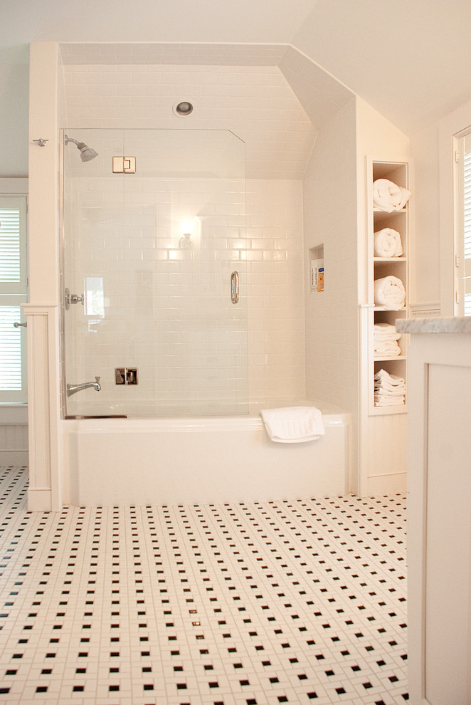Réalisation d'une salle de bain tradition avec une baignoire en alcôve, un combiné douche/baignoire, un carrelage blanc, un carrelage métro et du carrelage bicolore.
