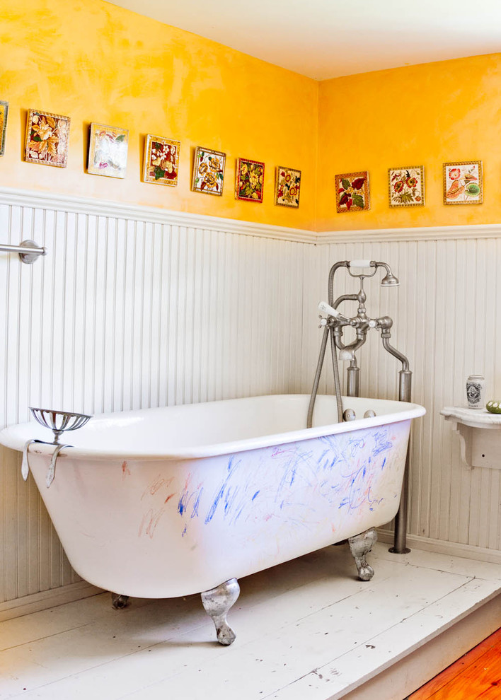 Claw-foot bathtub - country claw-foot bathtub idea in New York with yellow walls
