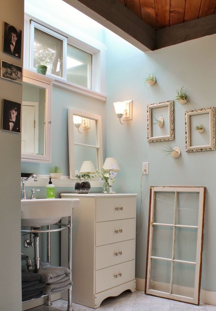 Diseño de cuarto de baño romántico con lavabo tipo consola y paredes azules