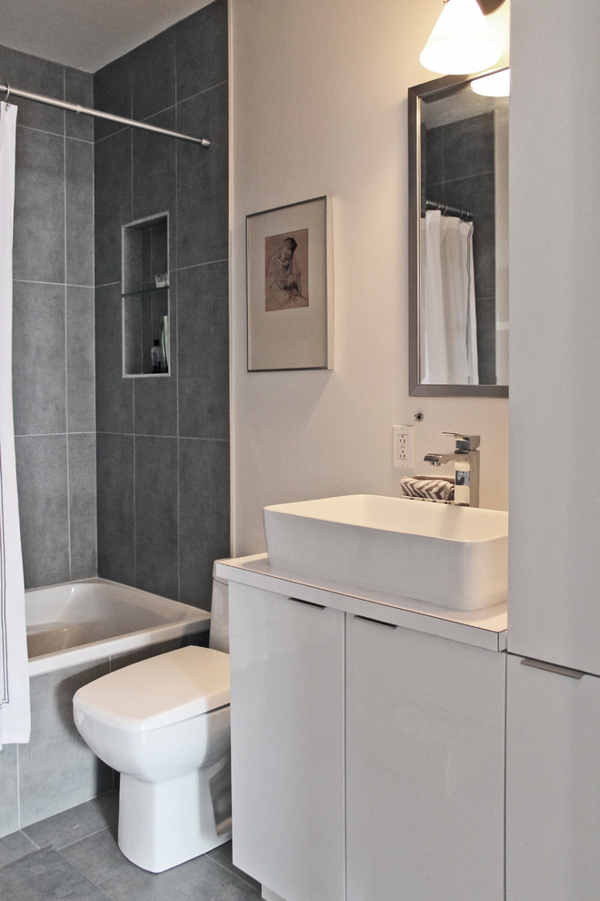 Стильный дизайн: маленькая главная ванная комната в современном стиле с плоскими фасадами, белыми фасадами, накладной ванной, душем над ванной, унитазом-моноблоком, серой плиткой, белыми стенами и настольной раковиной для на участке и в саду - последний тренд
