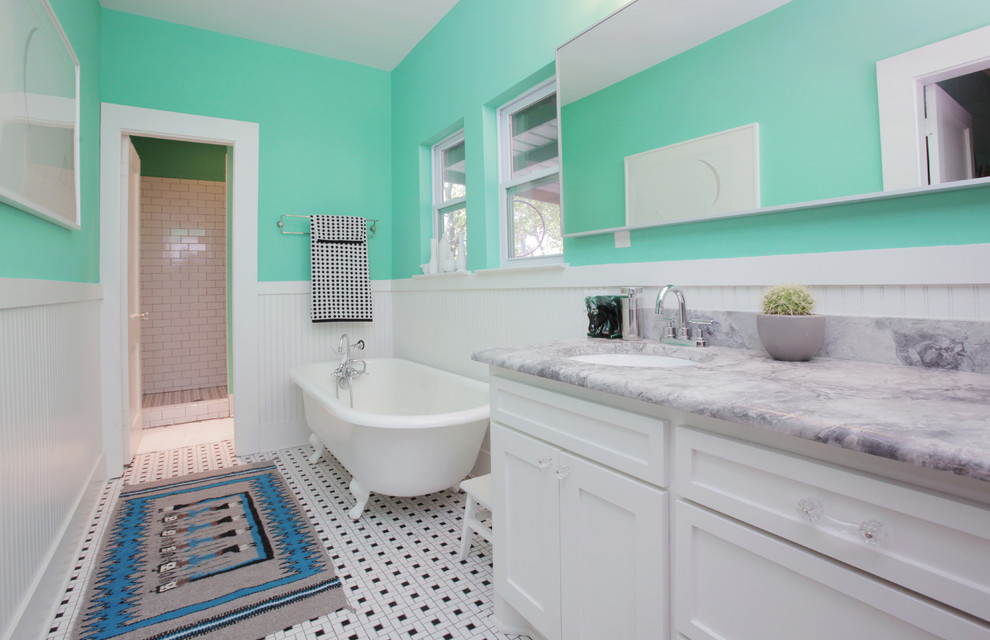Eklektisk inredning av ett badrum, med ett badkar med tassar, marmorbänkskiva och flerfärgat golv